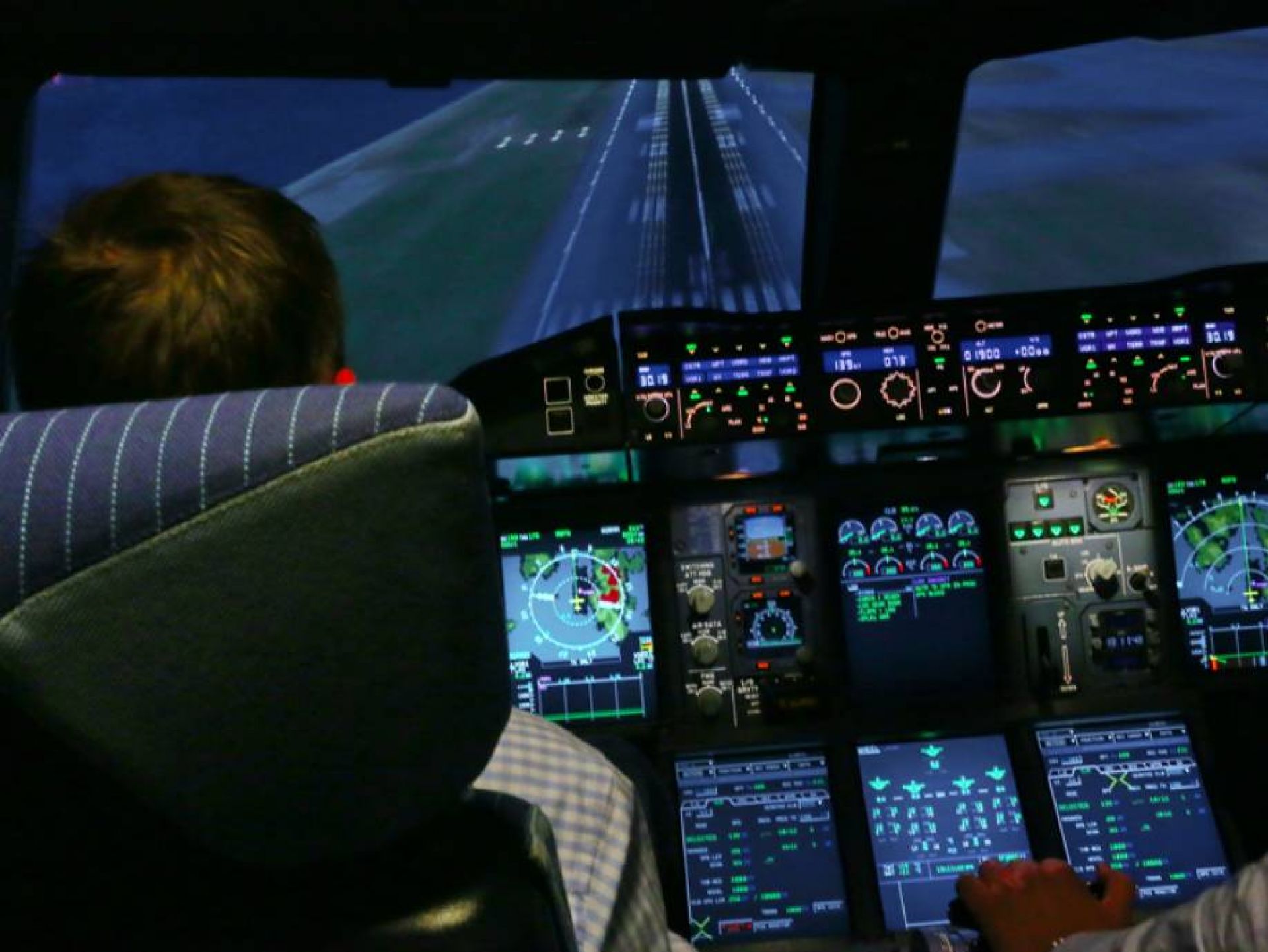 Landing approach by ProFlight customers in the Airbus A380, the cockpit is illuminated and many instruments are visible.