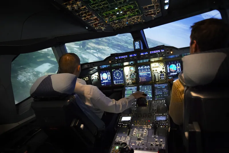 Kunden fliegen im Lufthansa Flugsimulator eine Kurve (Premiumliner)