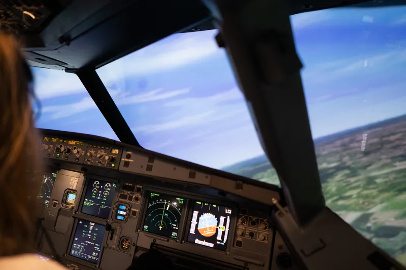 Kundin fliegt im Lufthansa Flugsimulator eine Kurve